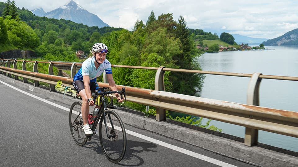 Fay Manner riding a bike on a bridge in her “ride to steep lines” project